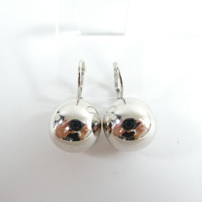 paire de boucles d'oreilles en argent en forme de boules, posées sur une surface blanche, sur fond blanc