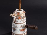 a small tea pot with a wooden handle on a table