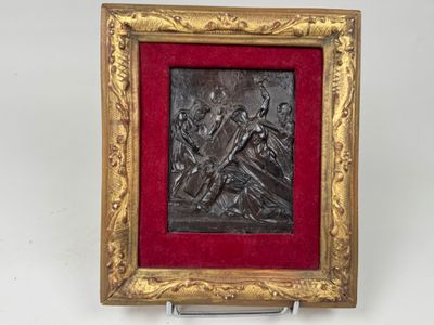 un relief antique en bronze représentant un homme et une femme tenant une croix