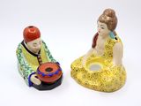 two figurines of a man and a woman sitting next to each other