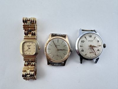 trois types de montres sont présentés sur une surface blanche