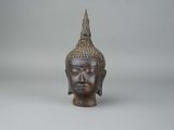 une vieille tête de Bouddha en bronze sur fond blanc