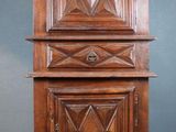 une vieille armoire en bois posée sur un tapis rouge