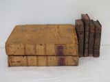 three old books sitting on top of each other on a white surface