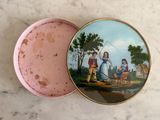 a pink box with a painting on it on a table