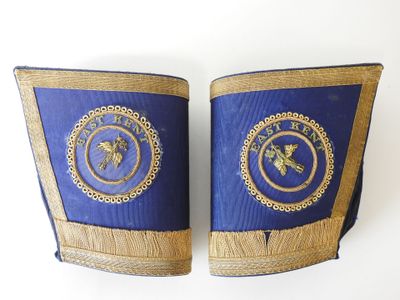 une paire de manchettes bleues et dorées ornées d'un emblème représentant un lion