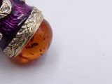 an image of a purple and gold necklace with an owl on it