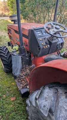 a red tractor that is parked in the grass