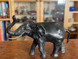 statue d'un éléphant posée sur une table devant une bibliothèque