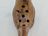 an image of a wooden bird with holes in it ' s beak