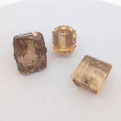 trois pierres de couleurs différentes posées sur une surface blanche, sur fond blanc