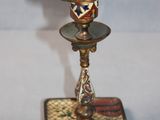 a small metal candle holder with a decorative design on it