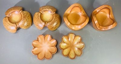 cinq pièces de poterie posées les unes à côté des autres sur une table