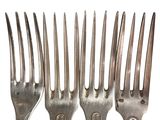 four forks that are sitting next to each other