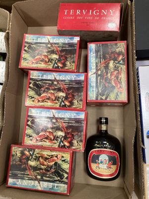 un carton contenant une bouteille d'alcool et une boîte de livres