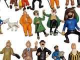 many figurines of different men and dogs on a white background