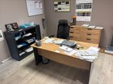 a desk with a laptop and a file cabinet in the corner