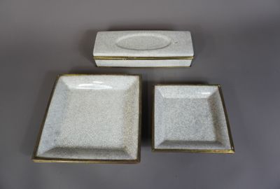 trois assiettes blanches aux bords dorés sont posées sur une table