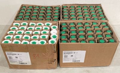 boxes of green and white cupcakes sitting on top of a counter