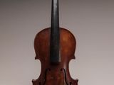 un vieux violon posé sur une table près d'un mur