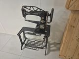 a black sewing machine sitting on a stand in the corner of a room