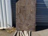 a pile of wooden sticks sitting on the ground next to a garage door