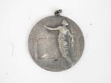 a silver medal with a woman on it hanging on a wall
