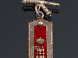 a silver and red medal with a bird on it