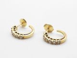 une paire de boucles d'oreilles créoles en or et diamants sur fond blanc