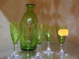 Des bouteilles et des verres sont alignés sur une table en verre.