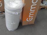 une poubelle blanche posée à côté d'une pile de cartons