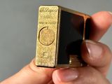 a person holding a gold and black lighter in their hand
