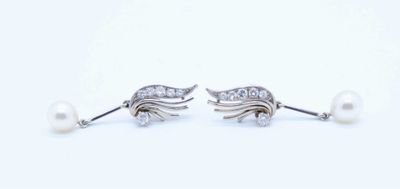 pair of pearl and diamond earrings on a white background