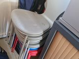 a pile of luggage sitting on the floor next to a stack of chairs