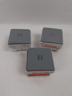 trois appareils électroniques argentés et rouges posés sur une surface blanche