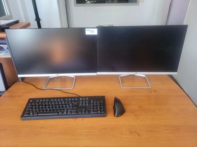 deux écrans d'ordinateur et un clavier sur un bureau