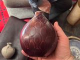 a person holding a vase in their hand on the floor