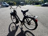 un vélo noir garé sur un parking à côté d'un autre parking