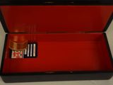 a red box with a card and a bottle in it