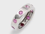 a close up of a ring with pink stones on a white background