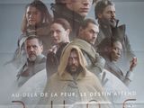 affiche de cinéma représentant un homme barbu debout devant un groupe de personnes