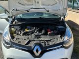 le moteur d'une voiture blanche, le capot ouvert, dans un parking