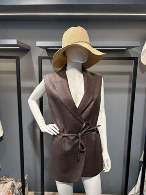 un mannequin portant une robe marron et un chapeau, exposé