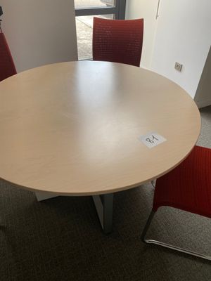 an image of a round table with red chairs