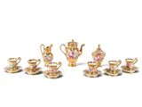 a group of miniature tea and coffee sets on a white surface
