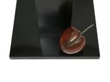 sculpture of an apple on a black plate with a white background