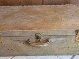 an old suitcase sitting on the floor next to a cabinet