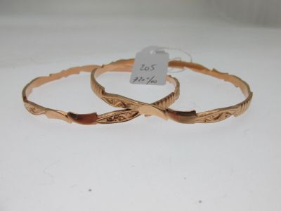 deux bracelets rigides de couleur dorée, ornés de motifs gravés