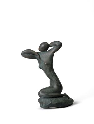 une statue de femme assise au sommet d'un rocher