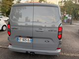 a grey van parked in a parking lot with other cars in the background